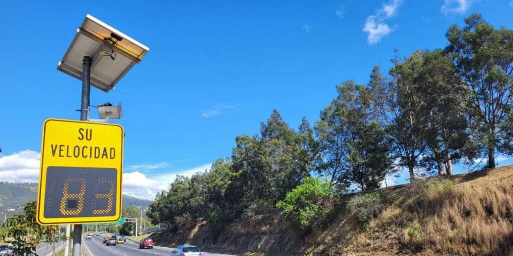 Panel digital mostrando límites de velocidad en carretera ecuatoriana, con un radar de control visible.