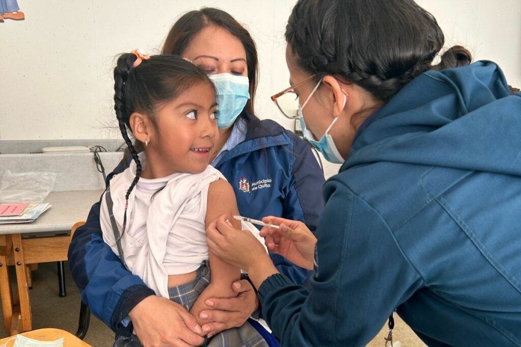 Doctoras del Ministerio de Salud Pública vacunan a una niña durante la campaña contra la tosferina en Manabí y Santo Domingo.