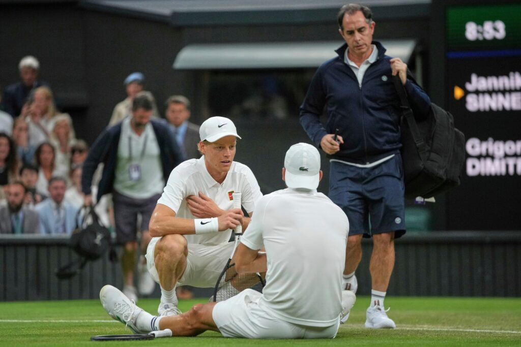 Jannik Sinner consuela a Grigor Dimitrov tras su retiro en Wimbledon 2025