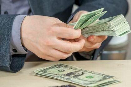 Persona contando billetes estadounidenses