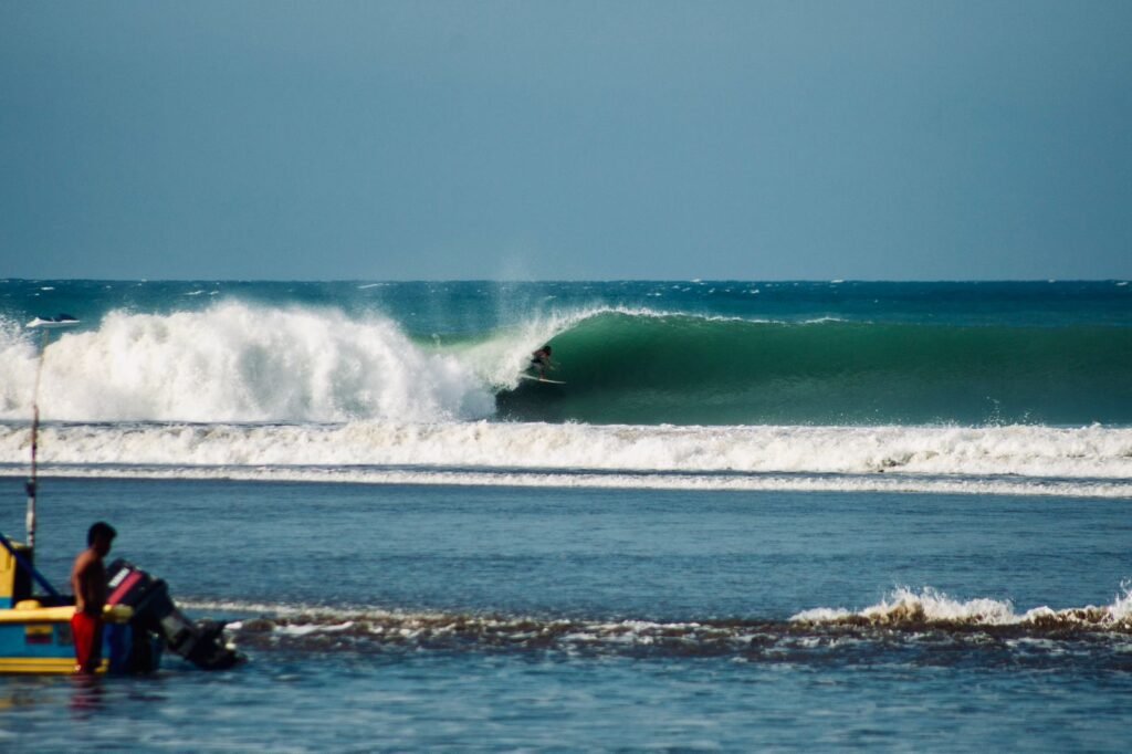 Olas rompiendo en la playa y paisajes costeros ecuatorianos, representando la protección de olas propuesta legalmente