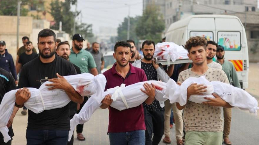 Palestinos hacen fila para recibir ayuda humanitaria en Gaza mientras soldados vigilan desde torres de control israelíes