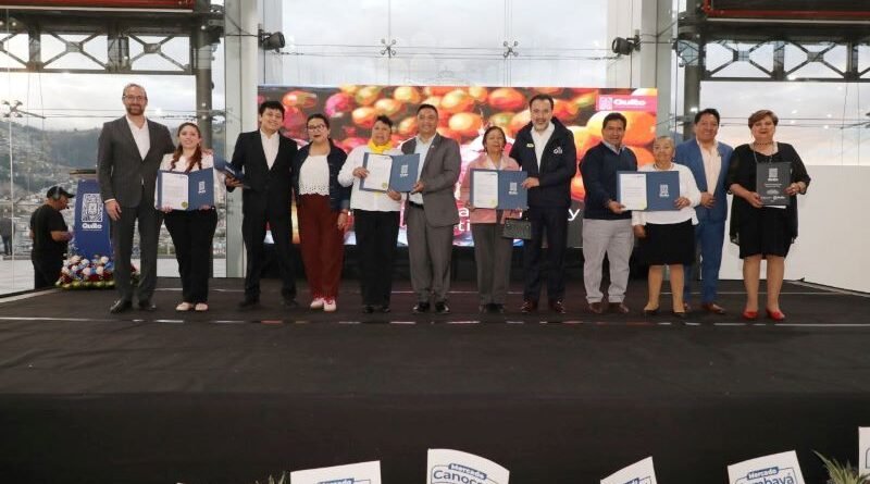 Comerciantes recibiendo cartas de adjudicación de puestos en mercados de Quito en ceremonia oficial del Municipio