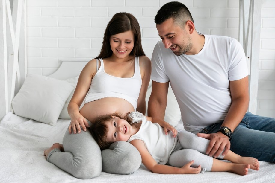 Médico pediatra examinando niño pequeño en consulta con padres
