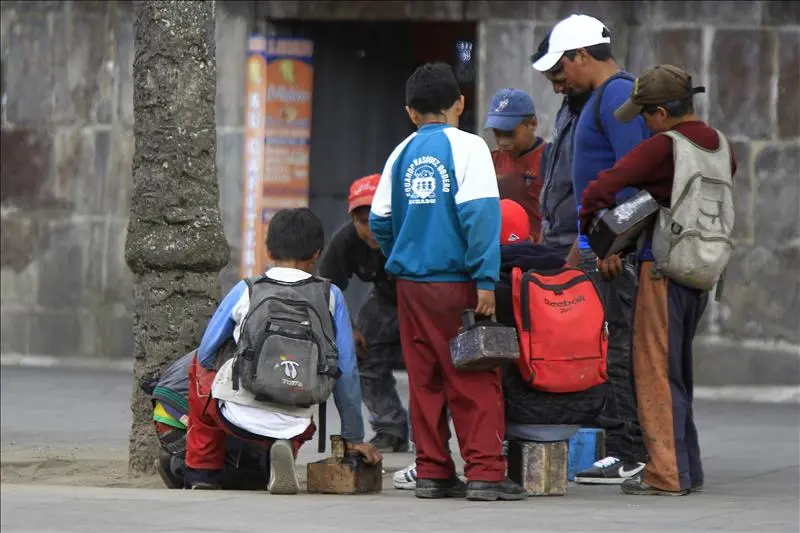 Niños trabajando en semáforos durante vacaciones escolares en Ecuador mostrando trabajo infantil