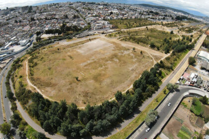 Vista del Parque Bicentenario de Quito con áreas verdes y vehículos abandonados