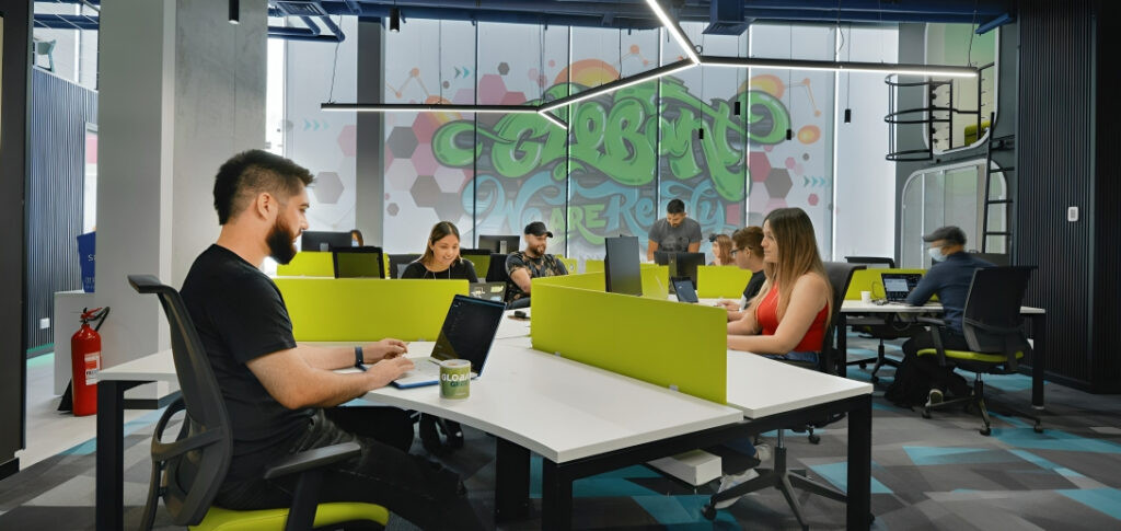 Desarrollador trabajando con inteligencia artificial y código en pantalla múltiple representando habilidades de programación del futuro