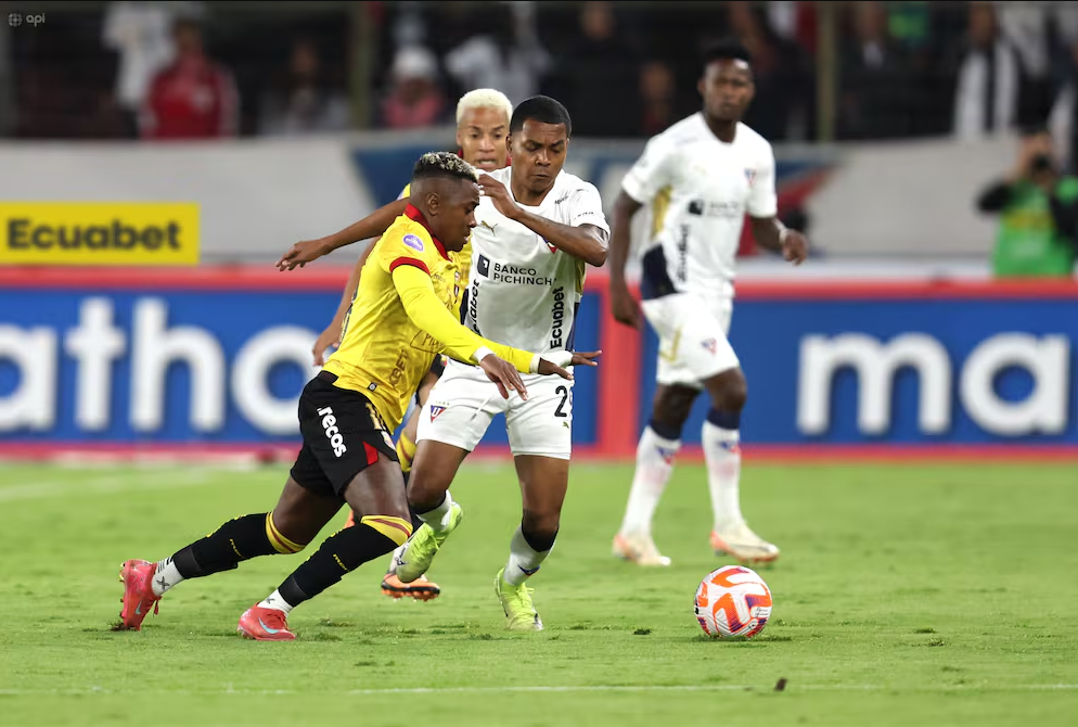 Jugadores de Liga de Quito y Barcelona SC disputan el balón en el estadio Rodrigo Paz Delgado.