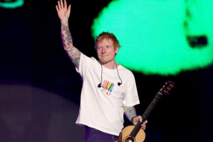 Ed Sheeran cantando en el escenario durante presentación en vivo con guitarra en concierto latinoamericano 2025