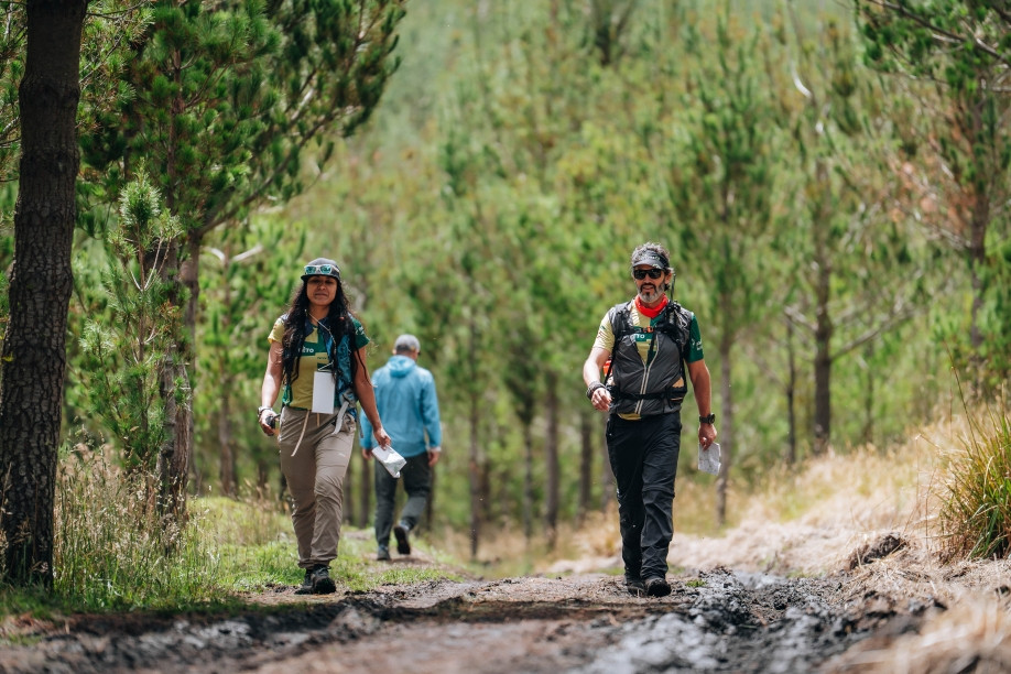 Sendero natural en bosque ecuatoriano con excursionistas practicando senderismo responsable entre vegetación nativa