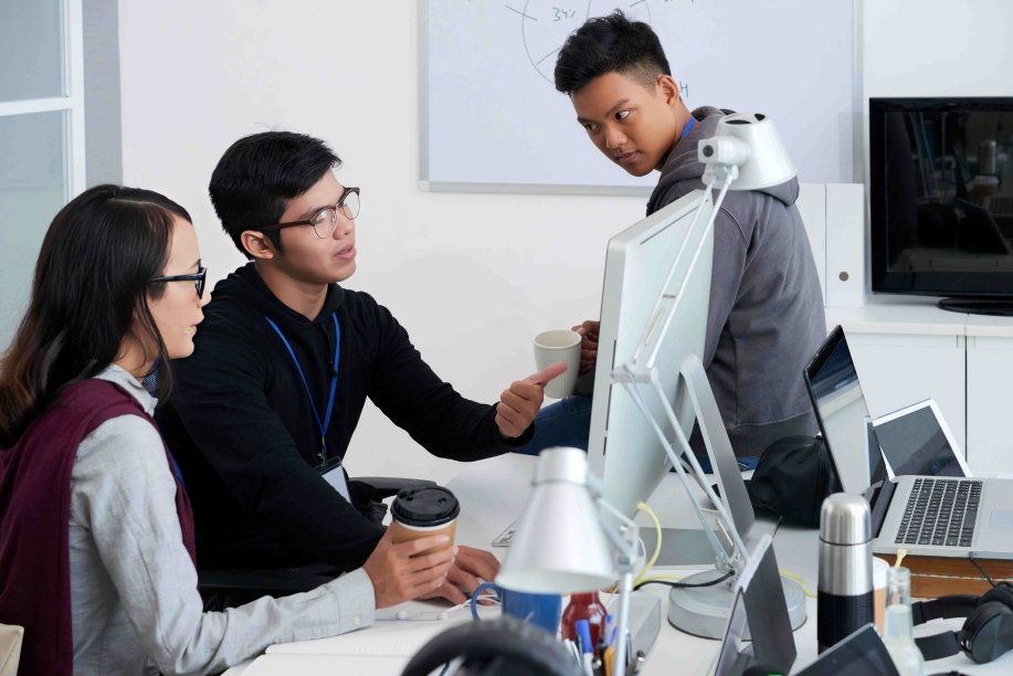 Profesionales ecuatorianos trabajando con tecnología de inteligencia artificial y análisis de datos en oficina moderna