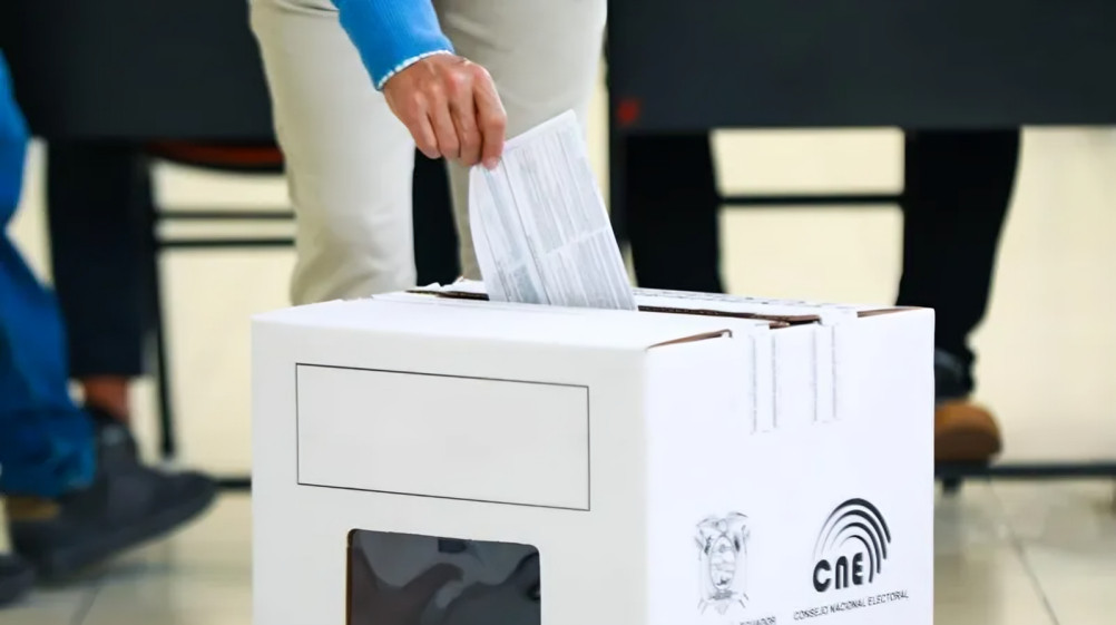 Urnas electorales con votantes ecuatorianos durante consulta popular en Ecuador 2025 en centro de votación nacional
