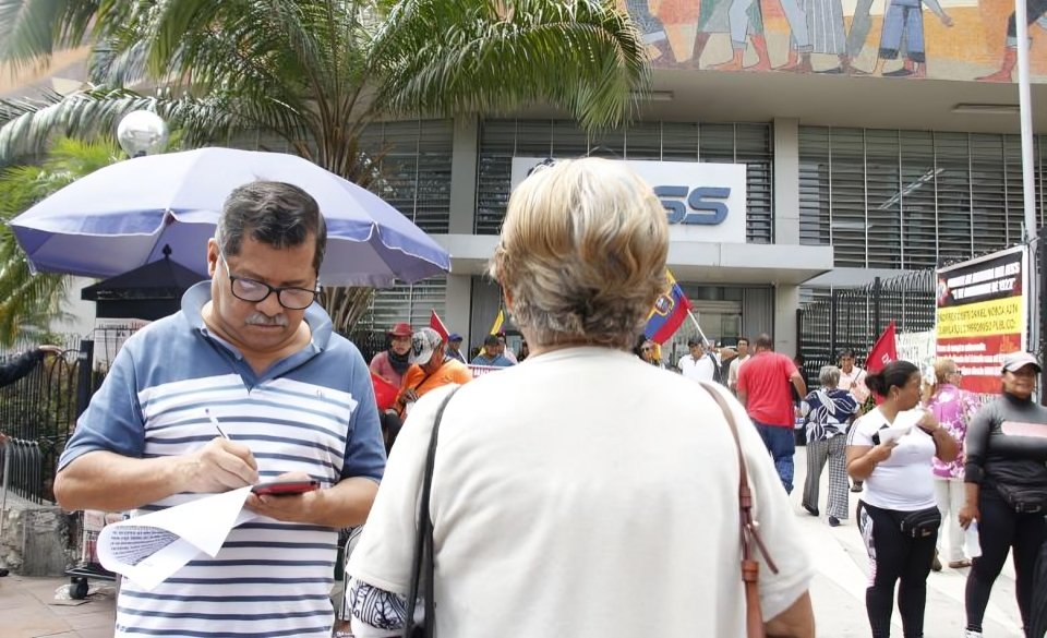 Adultos mayores jubilados protestando frente a oficinas del Biess por suplantación de identidad en créditos fraudulentos Ecuador