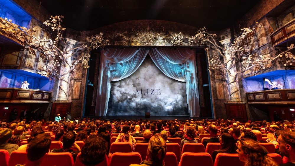 Proyectores Epson iluminando escenario Cirque du Soleil ALIZÉ en Theater am Potsdamer Platz Berlín con artistas acrobáticos