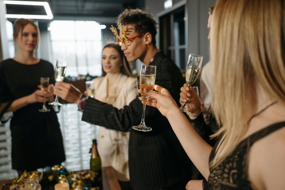 Profesionales celebrando en fiestas corporativas de fin de año con brindis en oficina decorada con luces navideñas