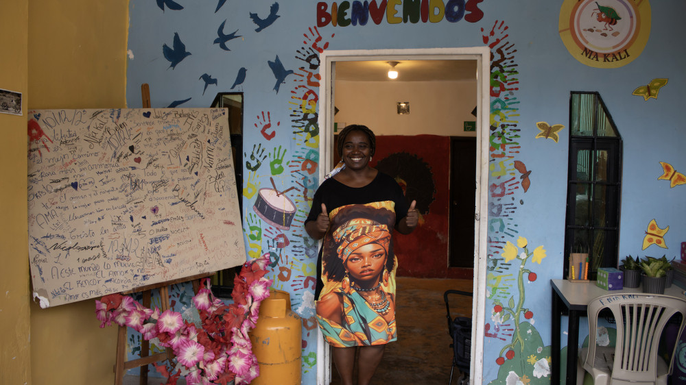 Inés Santos sonriendo junto a niños de la Fundación Nía Kali en la Isla Trinitaria de Guayaquil durante actividad comunitaria