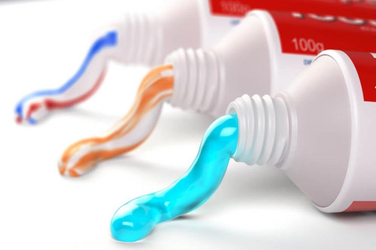 Imagen ilustrativa de una pasta dental con fluoruro de estaño, mostrando una alerta preventiva sobre sus posibles efectos adversos.
