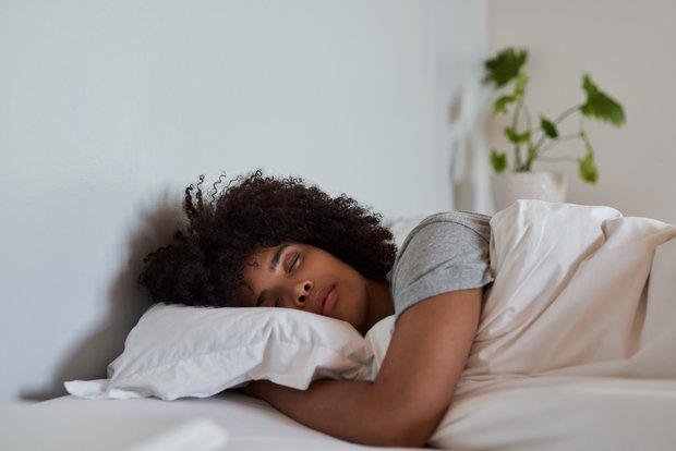 Mujer descansando plácidamente, durmiendo las horas de sueño necesarias para un óptimo rendimiento según estudios de Harvard