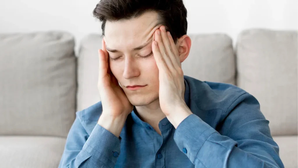 Persona sufriendo de migraña con un fondo que representa la salud mental.