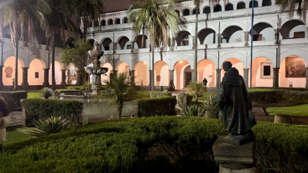 Fachada iluminada del convento e iglesia de Santo Domingo en el Centro Histórico de Quito durante un recorrido nocturno.