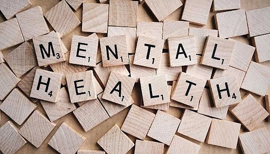 Profesional gestionando estrés en un entorno de oficina moderno, simbolizando la salud mental en la empresa.