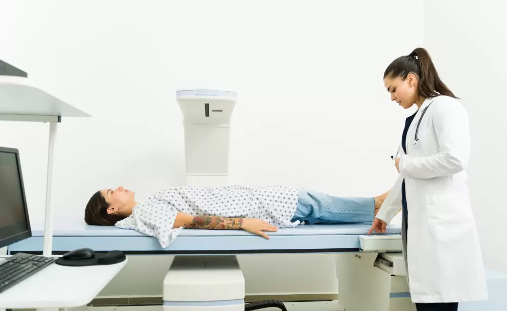 Mujer realizándose una densitometría ósea para evaluar la salud de sus huesos y prevenir la osteoporosis.