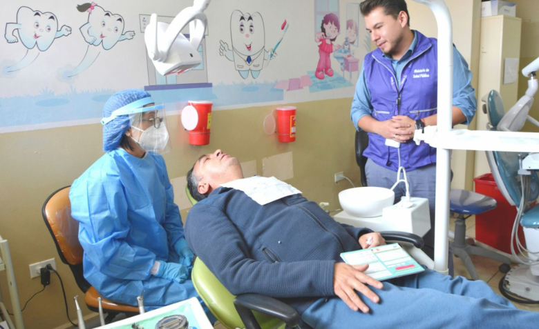 Médico atendiendo a un paciente en un centro de atención primaria en Ecuador.