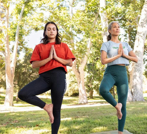 Personas practicando yoga en un entorno natural, demostrando flexibilidad y concentración.