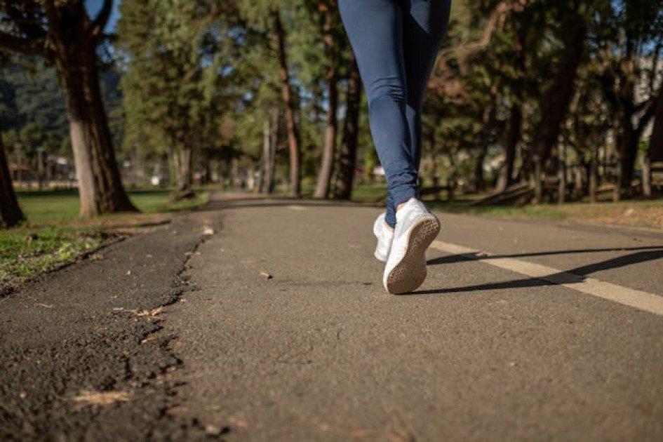 Persona trotando en un parque, símbolo del impacto positivo del ejercicio aeróbico en la salud mental