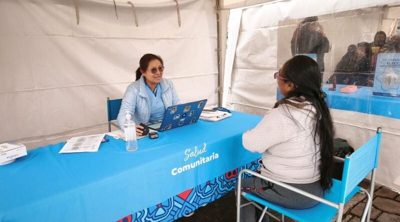 Mujeres recibiendo atención médica gratuita en una feria de salud comunitaria en Quito.
