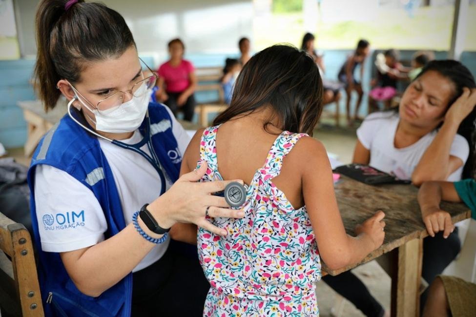 Un grupo diverso de refugiados y migrantes recibiendo atención médica en un entorno sanitario moderno y acogedor.