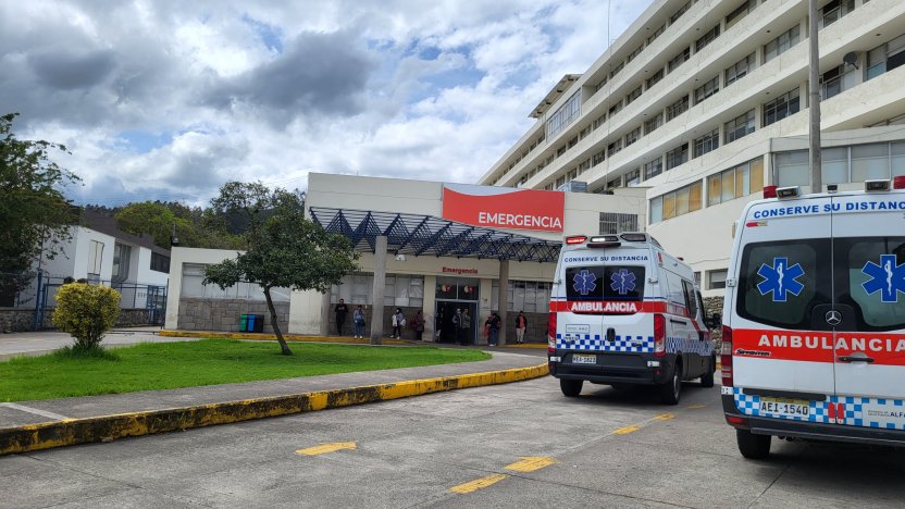 Madre preocupada junto a una ambulancia, simbolizando la lucha por el acceso a servicios de salud.
