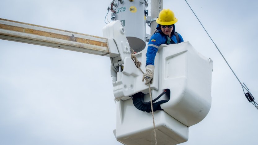 geniero revisando un panel de control eléctrico con luces de advertencia rojas encendidas, simbolizando el riesgo de colapso eléctrico en Ecuador