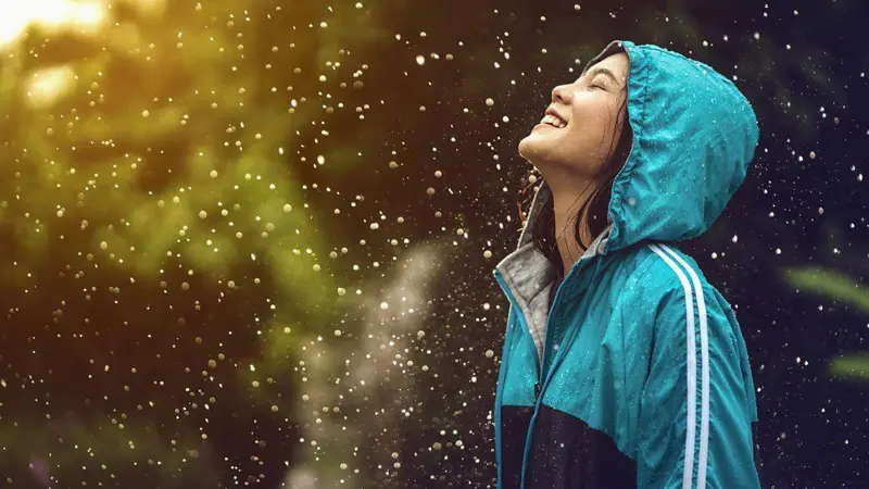 Persona disfrutando del aroma de la lluvia en un entorno natural.