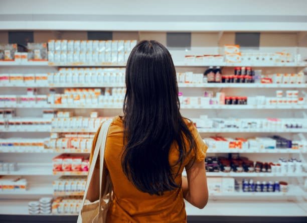 rofesional farmacéutico explicando a una mujer sobre salud femenina, menopausia y riesgo cardiovascular.