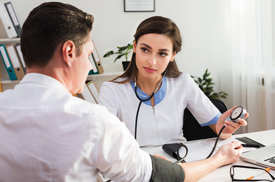 Médico atendiendo a paciente en consultorio — síntomas que indican consultar al médico
