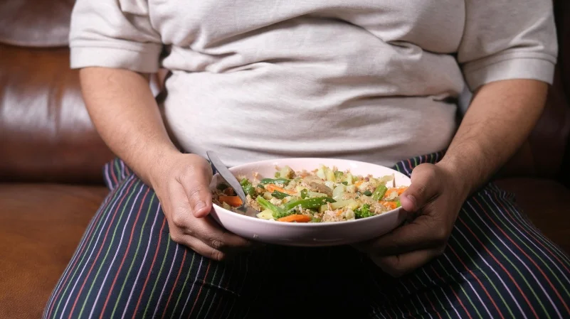 Grupo de personas con obesidad y profesionales de la salud interactuando en un entorno de apoyo, simbolizando el abordaje integral de 'SEEDO Contigo'.
