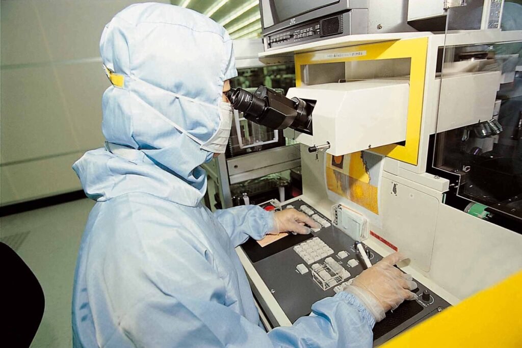 Línea de producción robotizada manipulando obleas de silicio purificado dentro de la industria de los semiconductores de TSMC.