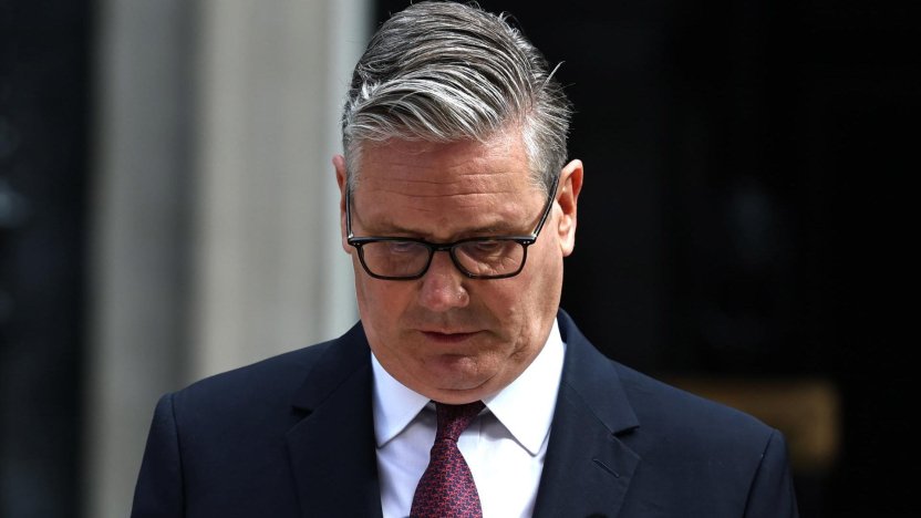 El primer ministro británico Keir Starmer habla seriamente detrás de un podio oficial de madera frente al número 10 de Downing Street.