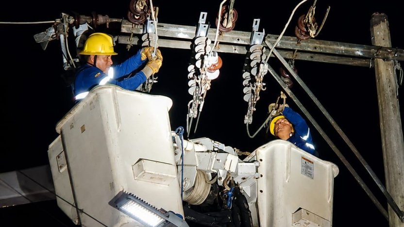 Personal técnico de CNEL EP realizando trabajos de repotenciación de redes de media tensión para mitigar cortes de luz temporales en Guayaquil.