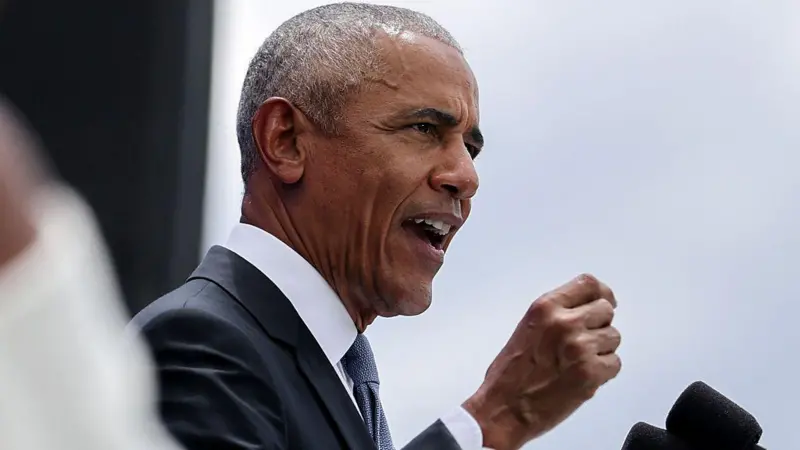 Fachada moderna de piedra de la torre principal del Centro Presidencial Obama rodeada por un frondoso parque público en Chicago
