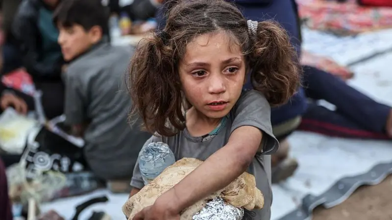 Ruinas de un edificio residencial destruido en Gaza rodeado de escombros bajo un cielo cubierto de humo gris.
