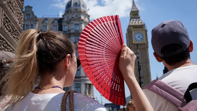 Ciudadanos europeos refrescándose en una fuente pública urbana bajo un sol brillante durante la alerta roja por calor.