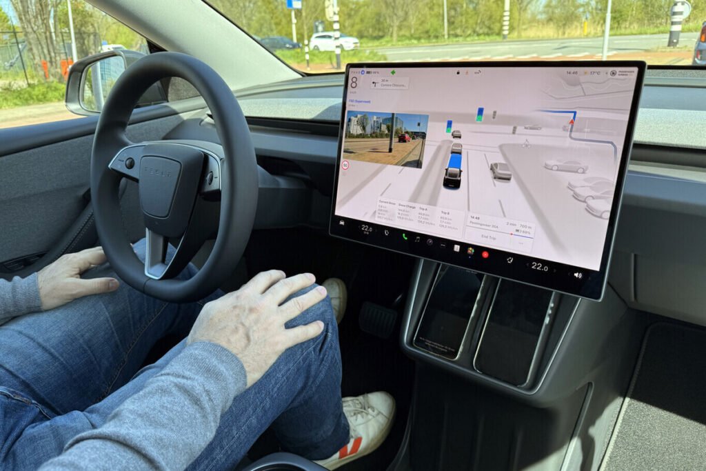 Vehículo eléctrico circulando por una carretera europea con la pantalla mostrando el sistema de conducción autónoma de Tesla supervisado.