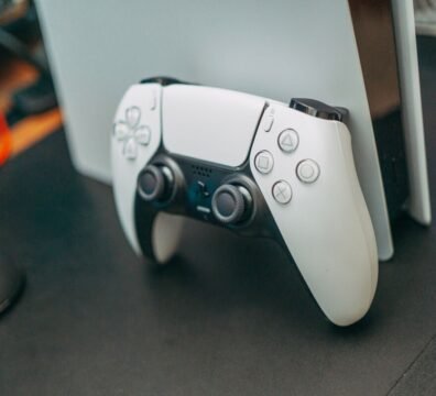 Consola de videojuegos doméstica PS5 Slim con lector de discos colocada en posición vertical, ilustrando cómo conseguir una PlayStation 5 más barata.