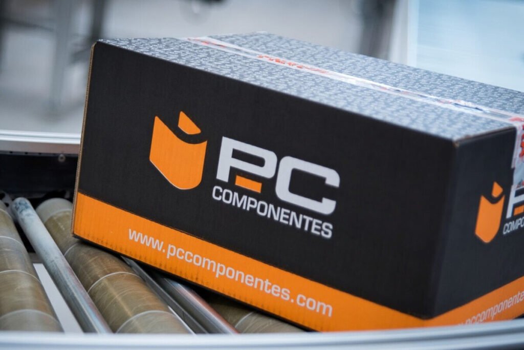 Una hilera de pantallas inteligentes encendidas exhibiendo paisajes coloridos en el almacén durante los PcDays de PcComponentes en televisores.