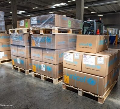 Descarga de cajas de asistencia humanitaria de UNICEF desde un avión de carga en el aeropuerto de Valencia tras una emergencia sísmica.