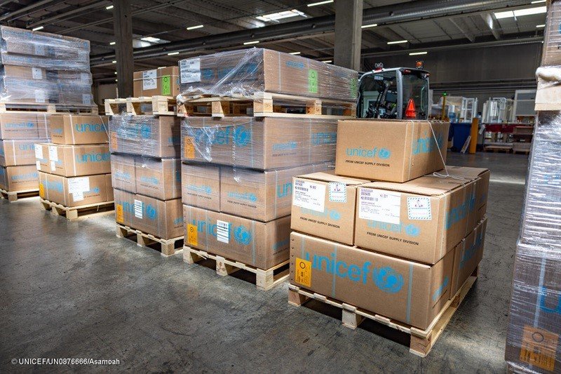 Descarga de cajas de asistencia humanitaria de UNICEF desde un avión de carga en el aeropuerto de Valencia tras una emergencia sísmica.