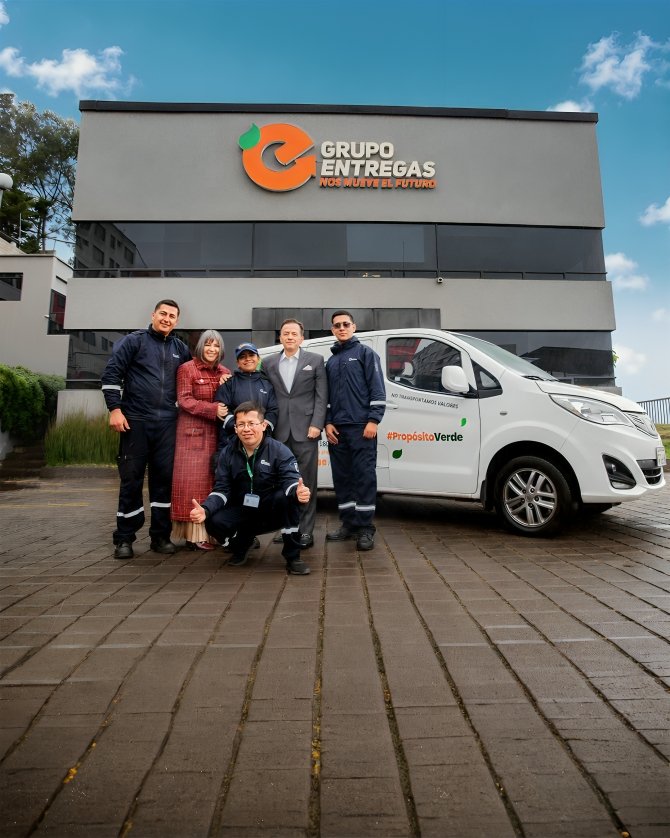 Equipo de Grupo Entregas junto a flota eléctrica sostenible frente a oficina matriz en Quito, Ecuador