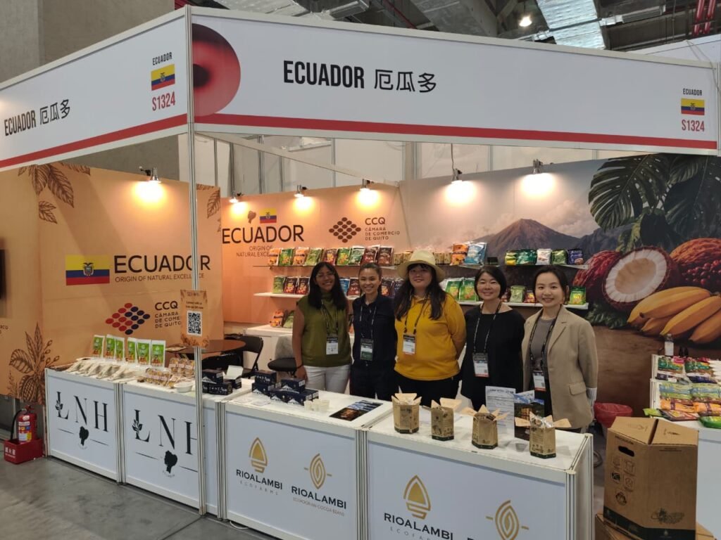 Empresarios ecuatorianos exhibiendo muestras de chocolate y frutas deshidratadas durante la promoción de la oferta ecuatoriana en FOOD TAIPEI 2026.